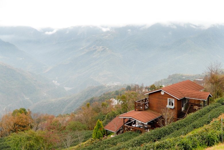 Beautiful red wooden house amidst a sea of mountains and clouds